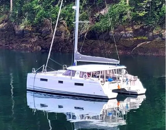 Slide: The Image of Nautitech 40 Open 2016 catamaran anchored in a serene, forested cove. - 20