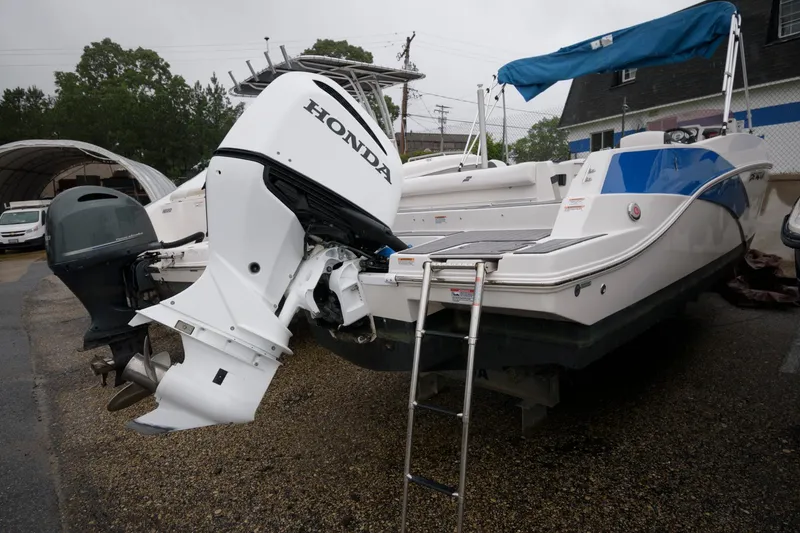 Slide: The Image of 2021 Starcraft SVX 231 OB boat with Honda outboard motor in a parking lot. - 1