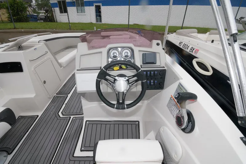 Slide: The Image of 2021 Starcraft SVX 231 OB boat cockpit with steering wheel and control panel. - 4