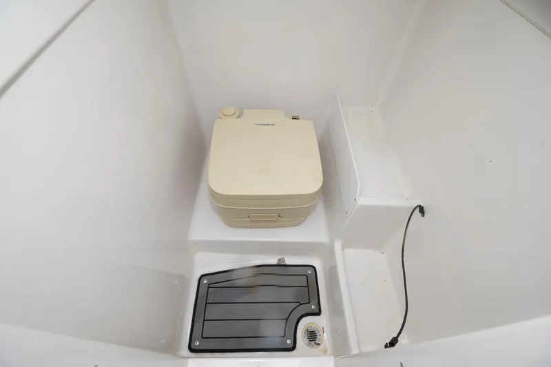 Slide: The Image of 2021 Starcraft SVX 231 OB boat interior with portable toilet and storage compartment. - 7