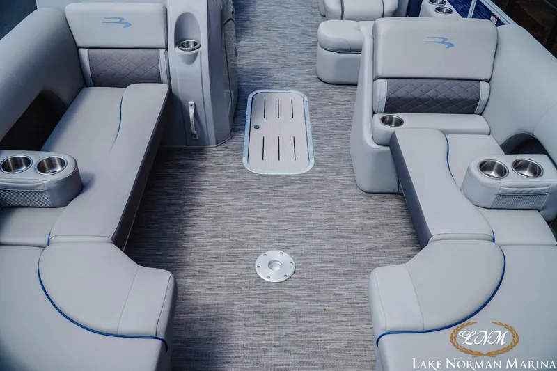 Slide: The Image of 2023 Bennington 23LSR boat interior with gray seating and cup holders at Lake Norman Marina. - 11