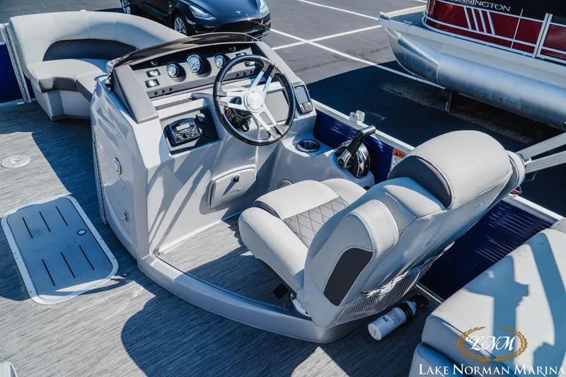 Slide: The Image of 2023 Bennington 23LSR pontoon boat interior with captain's chair and control console at Lake Norman Marina. - 7