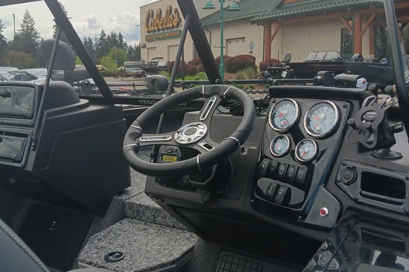 Slide: The Image of 2024 Tracker Targa V-19 WT boat dashboard with steering wheel and gauges. - 2