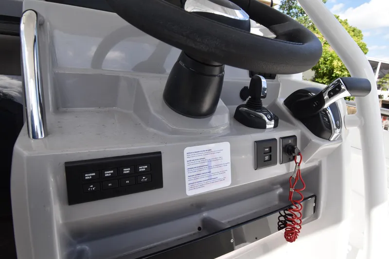 Slide: The Image of Control panel of a 2022 Jeanneau 7.5 Leader boat with steering wheel and switches. - 11