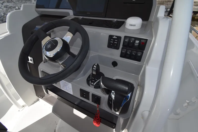 Slide: The Image of 2022 Jeanneau 7.5 Leader boat helm with steering wheel and control panel. - 12
