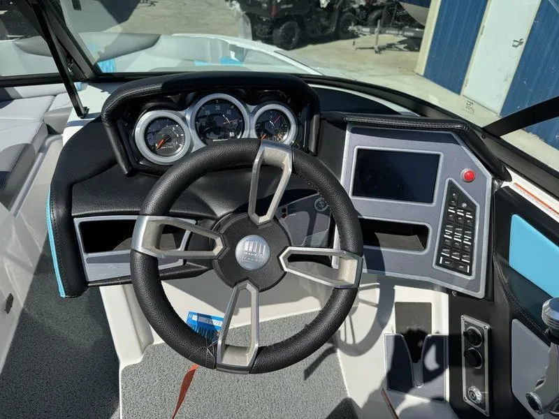 Slide: The Image of 2022 MasterCraft XT24 boat dashboard with steering wheel, gauges, and touchscreen controls. - 12