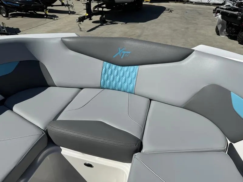 Slide: The Image of 2022 MasterCraft XT24 boat interior with gray and blue cushioned seating. - 29