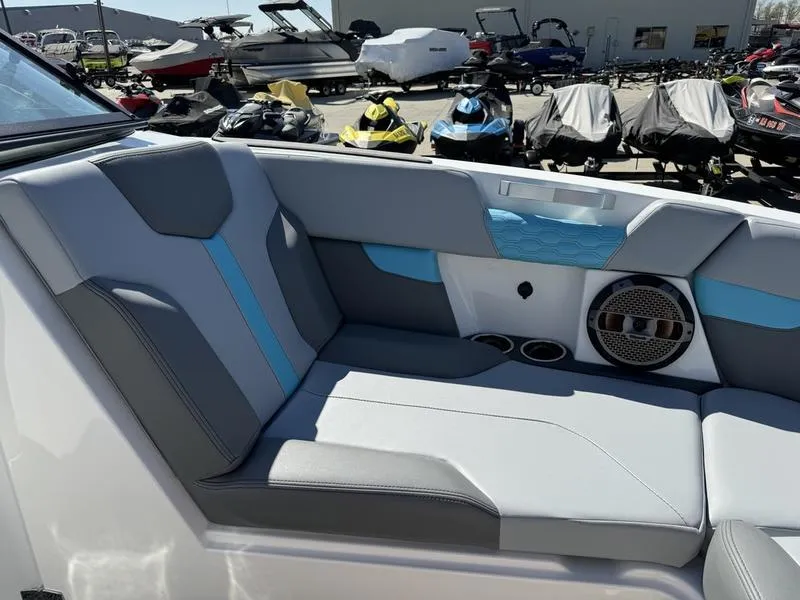 Slide: The Image of 2022 MasterCraft XT24 boat interior with gray and blue seating, speaker, and cup holders. - 31
