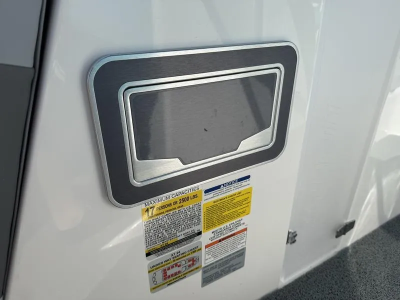 Slide: The Image of 2022 MasterCraft XT24 boat capacity and safety labels on white exterior. - 32