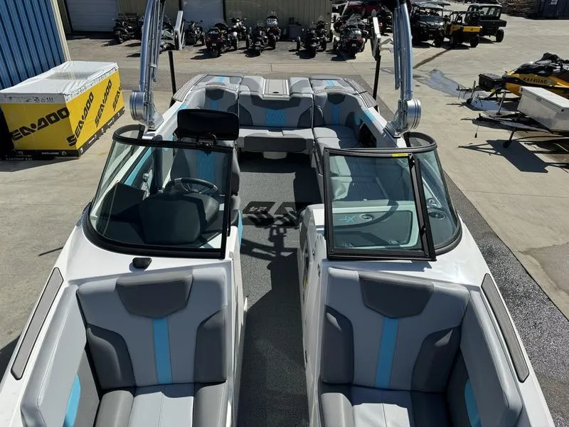 Slide: The Image of 2022 MasterCraft XT24 boat with gray and blue interior, docked at a marina. - 35