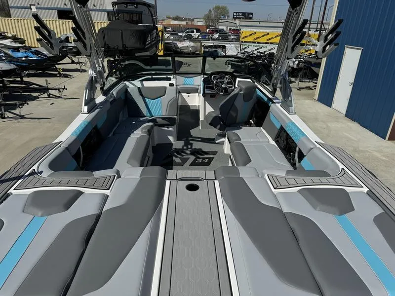 Slide: The Image of 2022 MasterCraft XT24 boat interior with gray and blue seating, docked at a marina. - 6