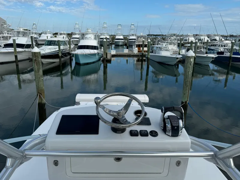 Slide: The Image of Helm of 2020 Invincible 40 Catamaran docked in marina with multiple boats. - 11