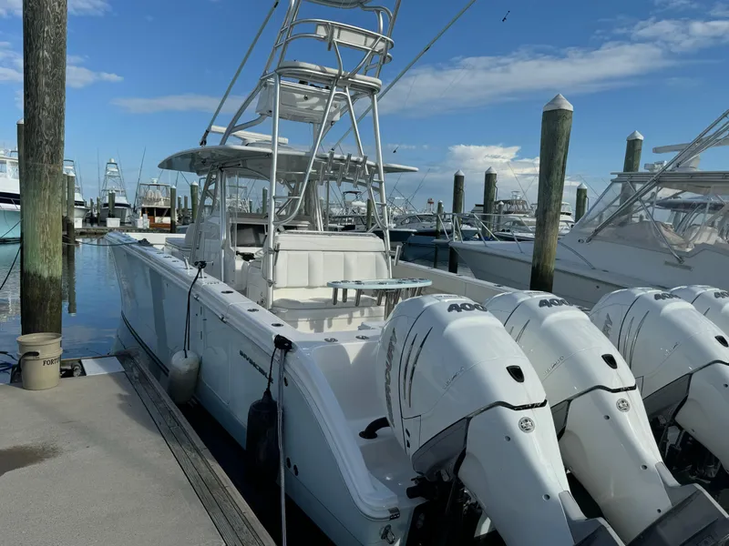 Slide: The Image of 2020 Invincible 40 Catamaran docked with triple outboard engines, clear sky background. - 23