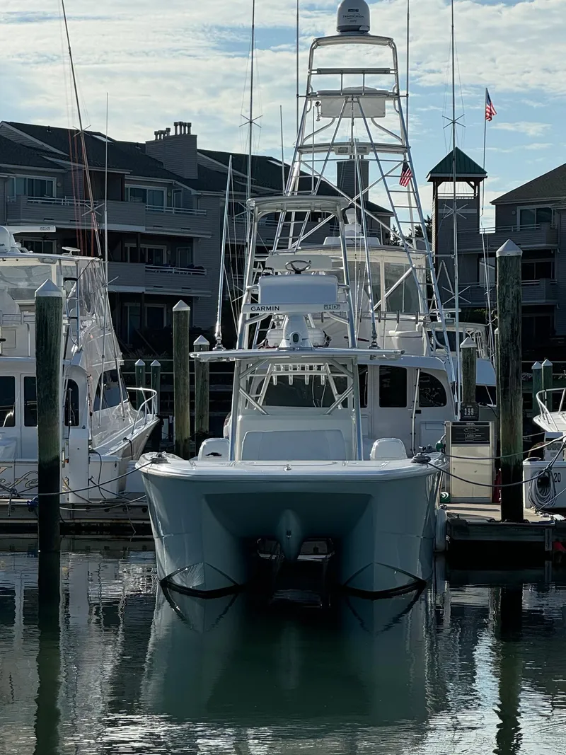 Slide: The Image of 2020 Invincible 40 Catamaran docked at marina with residential buildings in background. - 26