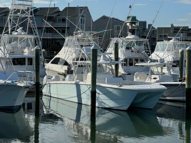 Slide: The Image of 2020 Invincible 40 Catamaran docked among other boats in a marina setting. - 28