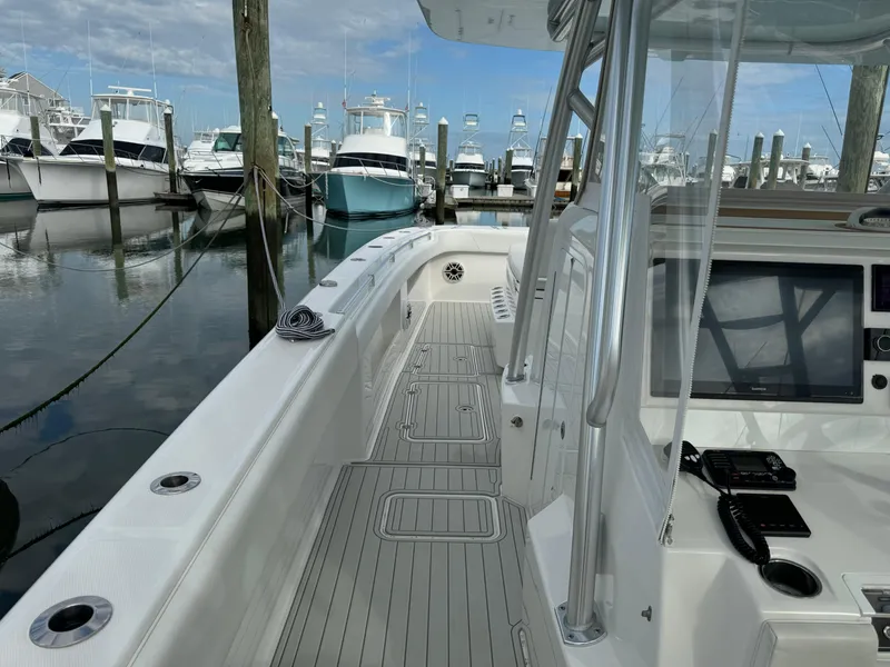 Slide: The Image of 2020 Invincible 40 Catamaran docked, showcasing sleek deck design and modern navigation equipment. - 6