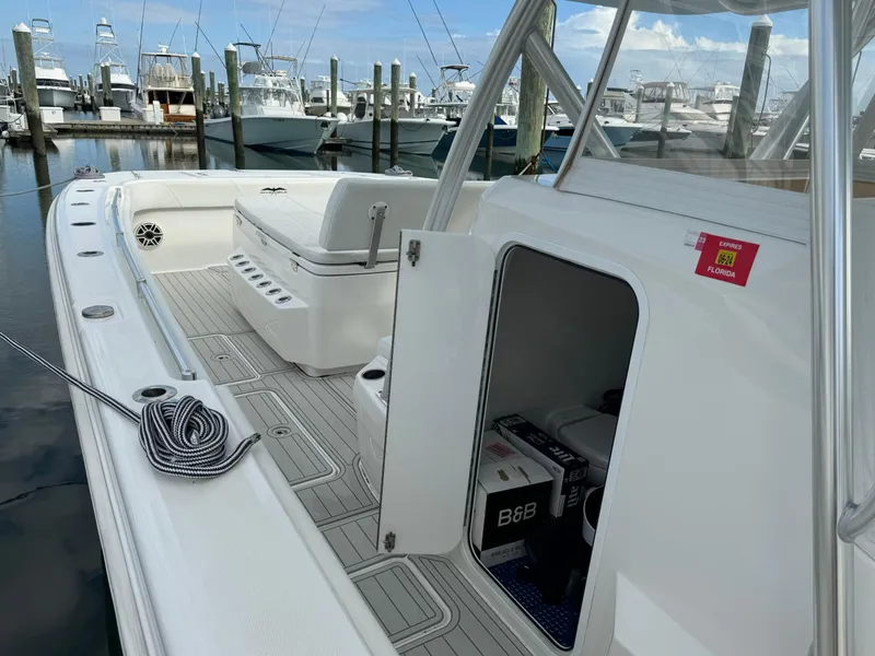 Slide: The Image of 2020 Invincible 40 Catamaran docked, open storage compartment, coiled rope on deck. - 7