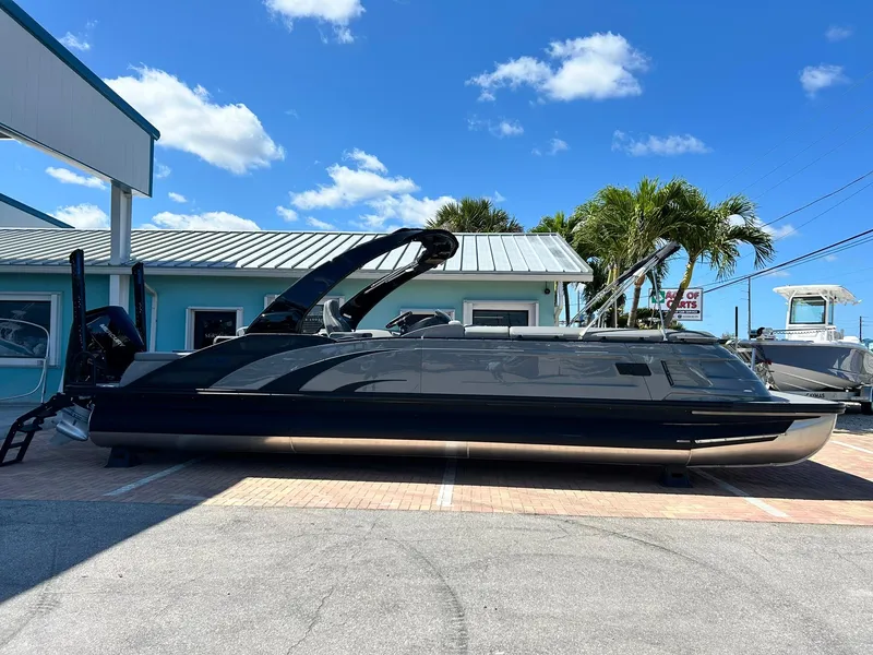 Slide: The Image of 2024 Bennington 28 QXSBA x1 luxury pontoon boat in a marina. - 2