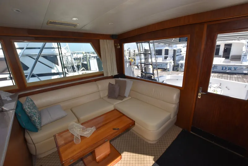 Slide: The Image of Interior of 1987 Hatteras SportFish yacht with leather seating and wooden table. - 10