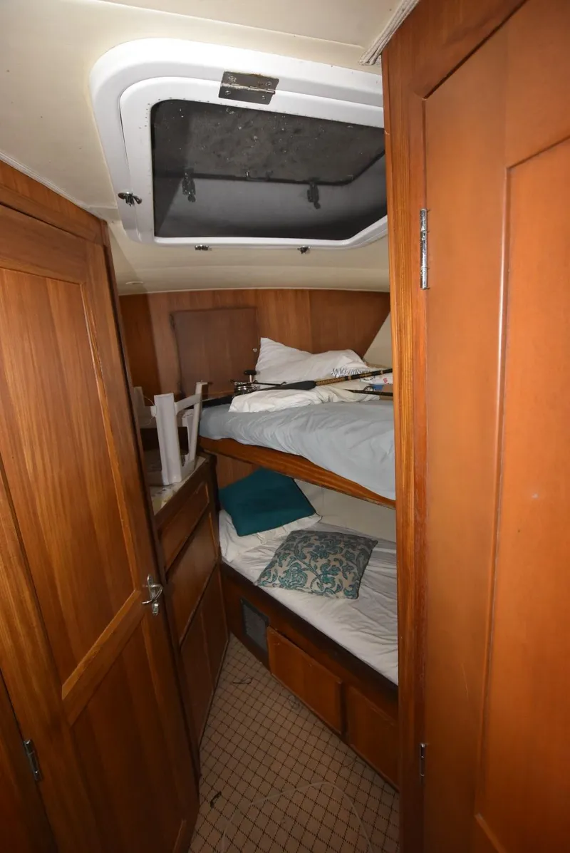 Slide: The Image of 1987 Hatteras SportFish cabin with wooden bunk beds and storage. - 21