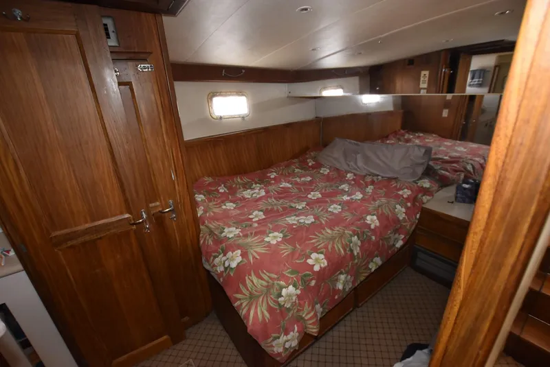 Slide: The Image of 1987 Hatteras SportFish cabin with floral bedspread and wooden interior. - 22