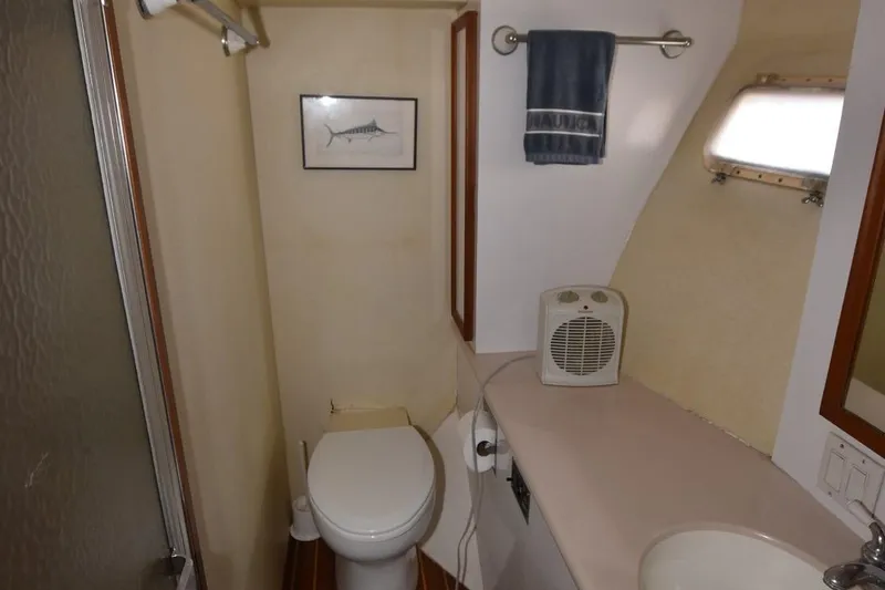 Slide: The Image of 1987 Hatteras SportFish (w/CATS) boat bathroom with toilet, sink, and shower. - 25