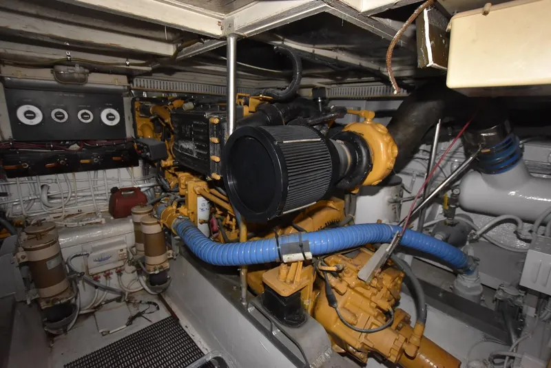 Slide: The Image of 1987 Hatteras SportFish engine room with CAT engines and blue hoses. - 29