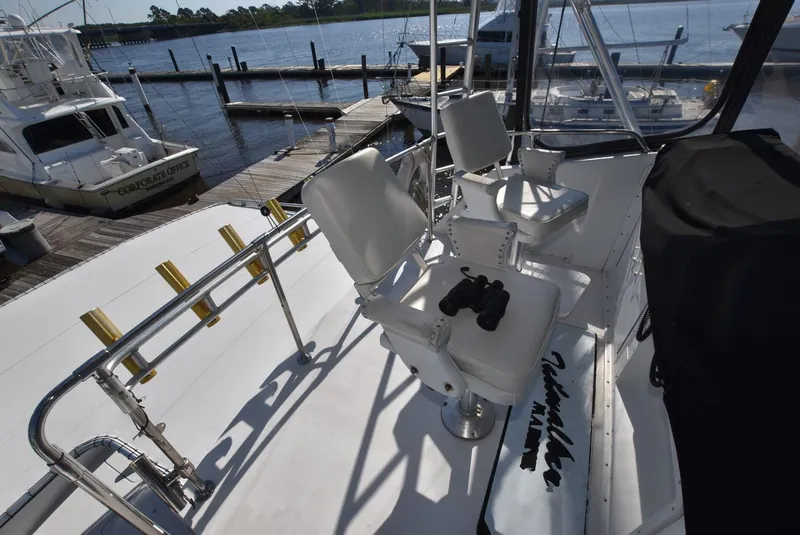 Slide: The Image of 1987 Hatteras SportFish (w/CATS) boat deck with captain's chairs and binoculars. - 4