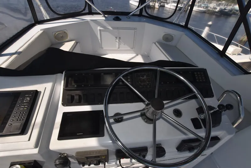 Slide: The Image of 1987 Hatteras SportFish boat helm with steering wheel and control panel. - 8