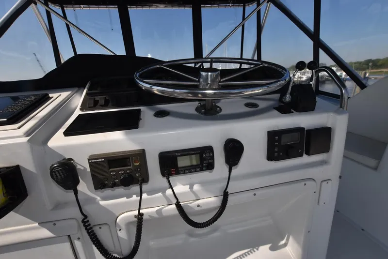 Slide: The Image of 1987 Hatteras SportFish boat helm with steering wheel and navigation equipment. - 9