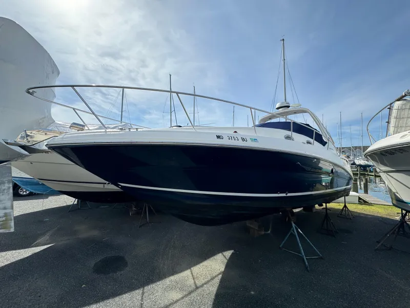 The Image of 2006 Sea Ray 320 Sundancer boat on dry dock under a clear sky. - 0
