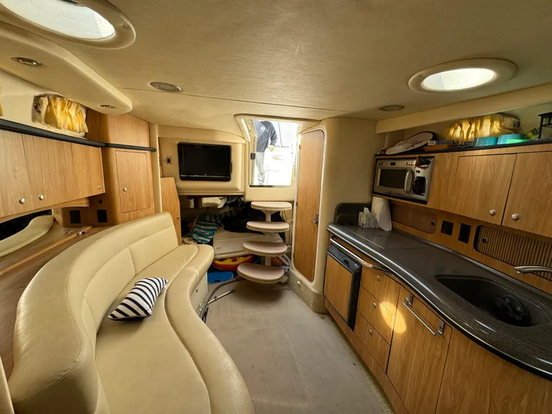 Slide: The Image of Interior of 2006 Sea Ray 320 Sundancer yacht with kitchen, seating, and entertainment area. - 19