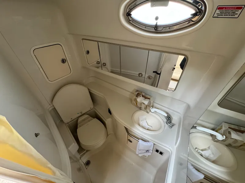 Slide: The Image of 2006 Sea Ray 320 Sundancer bathroom with toilet, sink, and mirror. - 26
