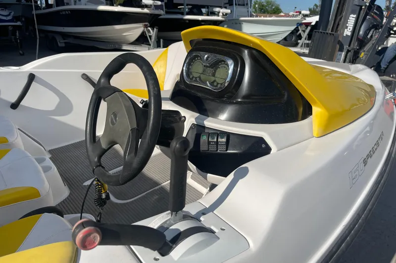 Slide: The Image of 2010 Sea-Doo 150 Speedster dashboard and steering wheel, yellow and white interior. - 12