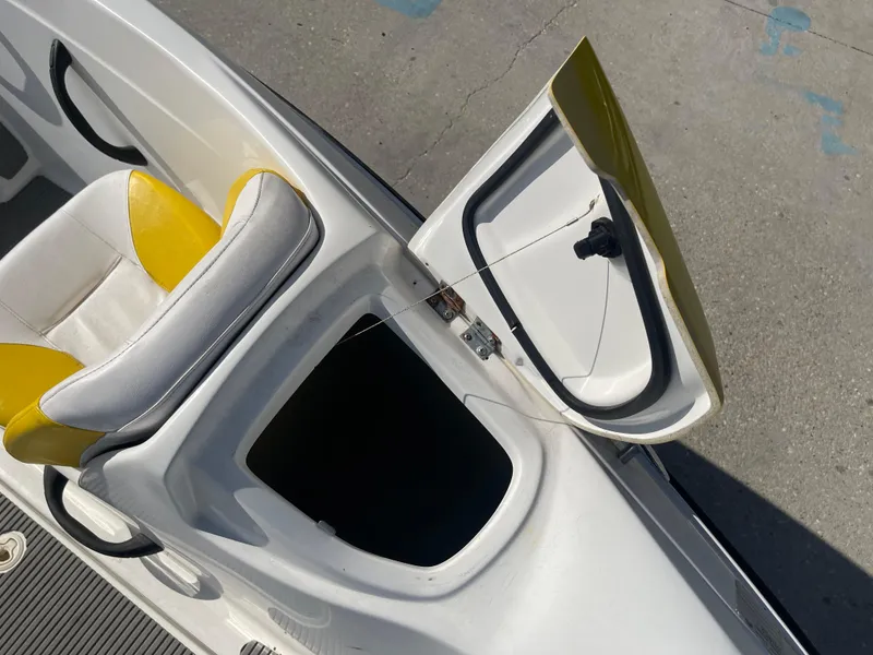 Slide: The Image of 2010 Sea-Doo 150 Speedster storage compartment with open lid and yellow seat. - 15