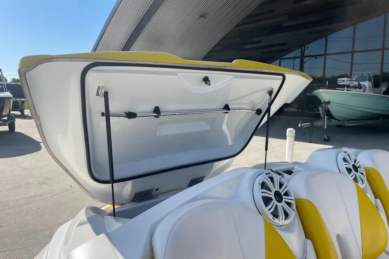 Slide: The Image of 2010 Sea-Doo 150 Speedster with open storage compartment and yellow-white seats. - 17