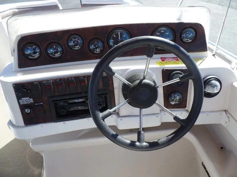 Slide: The Image of 1996 Hurricane Fun Deck boat dashboard with steering wheel and instrument panel. - 6