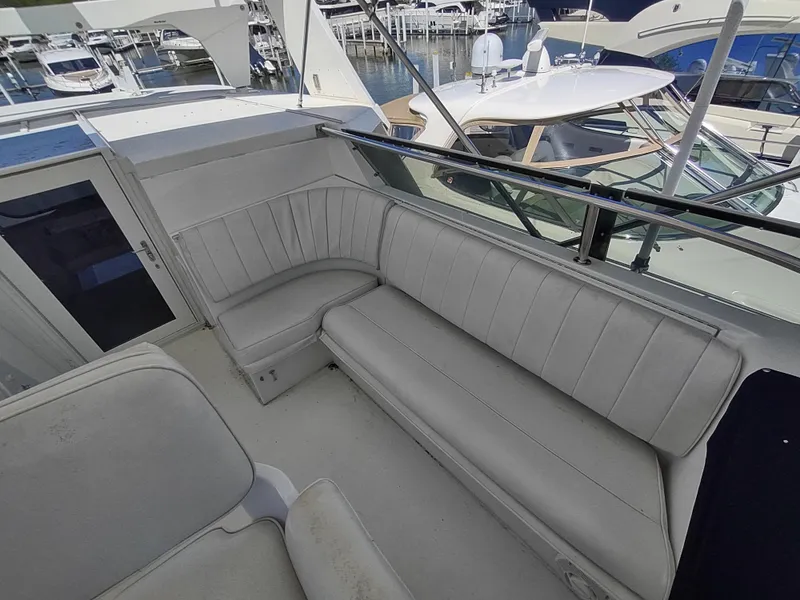 Slide: The Image of 1995 Hatteras 52 Cockpit Motor Yacht with spacious seating area at marina. - 10