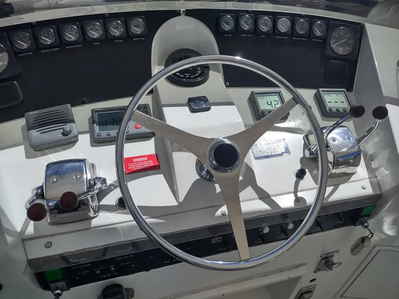 Slide: The Image of 1995 Hatteras 52 Cockpit Motor Yacht helm with gauges and controls. - 12