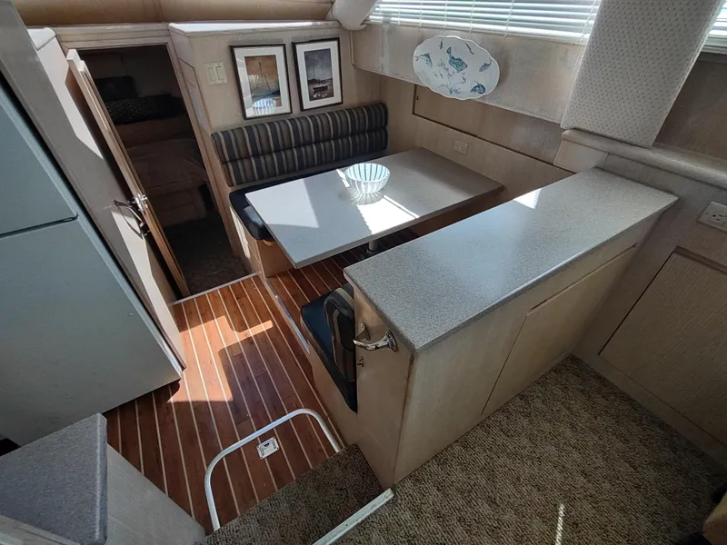 Slide: The Image of Interior of 1995 Hatteras 52 Cockpit Motor Yacht with dining area and wood flooring. - 18