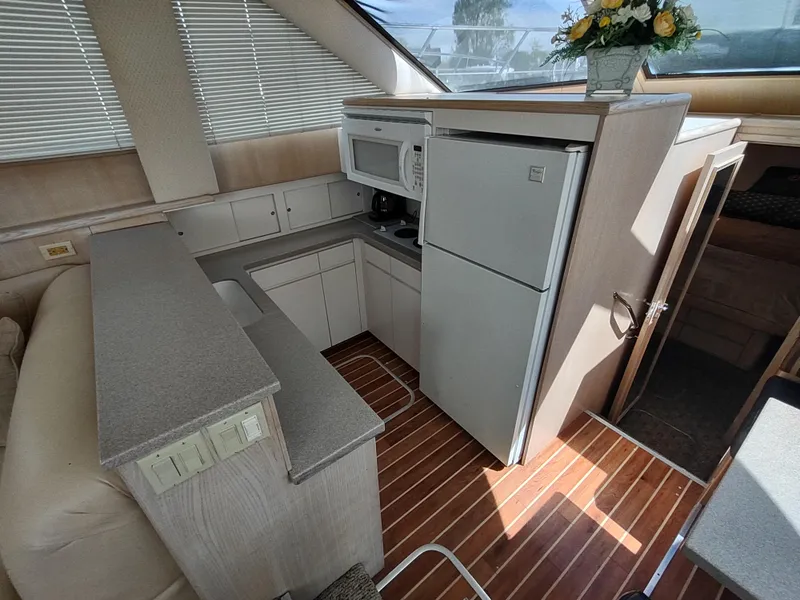 Slide: The Image of Interior of 1995 Hatteras 52 Cockpit Motor Yacht kitchen with appliances and wood flooring. - 19