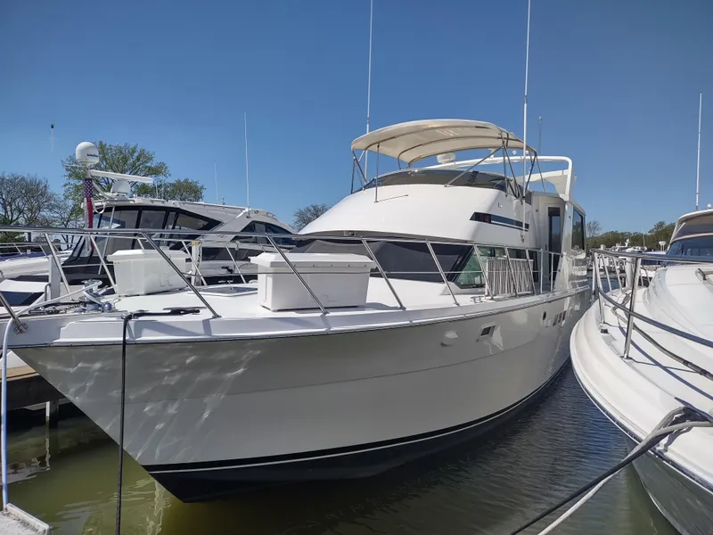 Slide: The Image of 1995 Hatteras 52 Cockpit Motor Yacht docked in marina under clear blue sky. - 2