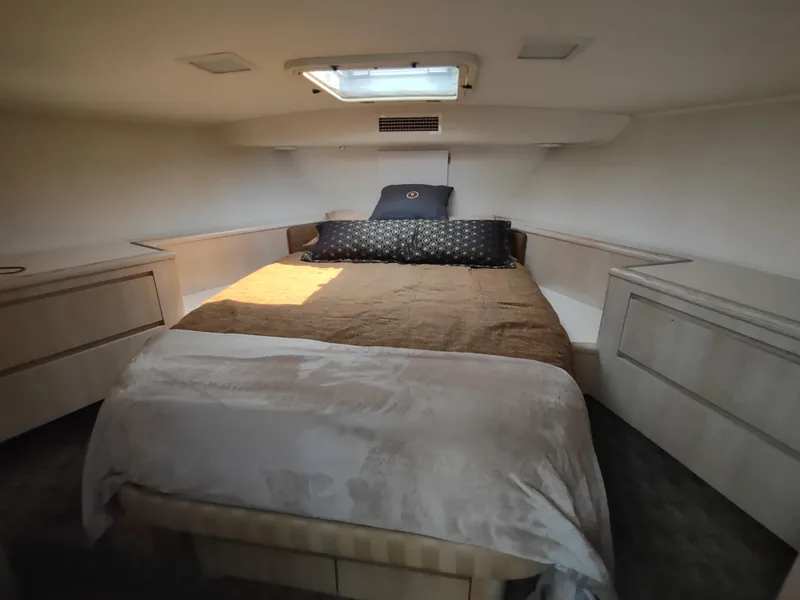 Slide: The Image of 1995 Hatteras 52 Cockpit Motor Yacht bedroom with cozy bed and overhead hatch. - 22