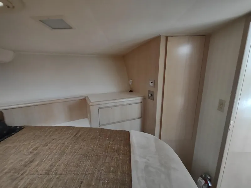 Slide: The Image of 1995 Hatteras 52 Cockpit Motor Yacht interior cabin with bed and storage. - 24