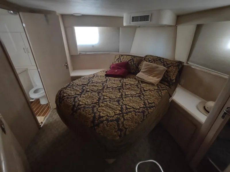 Slide: The Image of Bedroom interior of 1995 Hatteras 52 Cockpit Motor Yacht with patterned bedding and ensuite bathroom. - 28