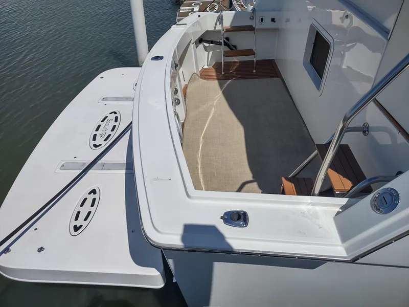 Slide: The Image of 1995 Hatteras 52 Cockpit Motor Yacht, spacious deck view with swim platform. - 3