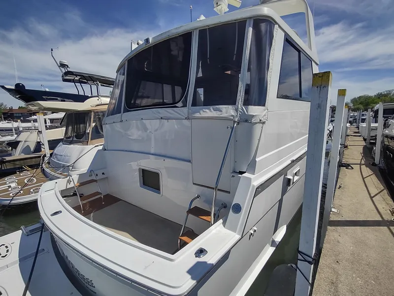 Slide: The Image of 1995 Hatteras 52 Cockpit Motor Yacht docked at marina under clear sky. - 4
