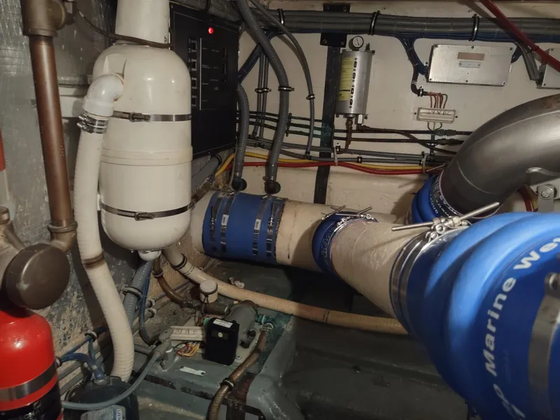 Slide: The Image of Engine room of 1995 Hatteras 52 Cockpit Motor Yacht with visible pipes and equipment. - 44