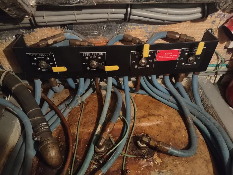 Slide: The Image of Engine room of 1995 Hatteras 52 Cockpit Motor Yacht with control panel and hoses. - 47