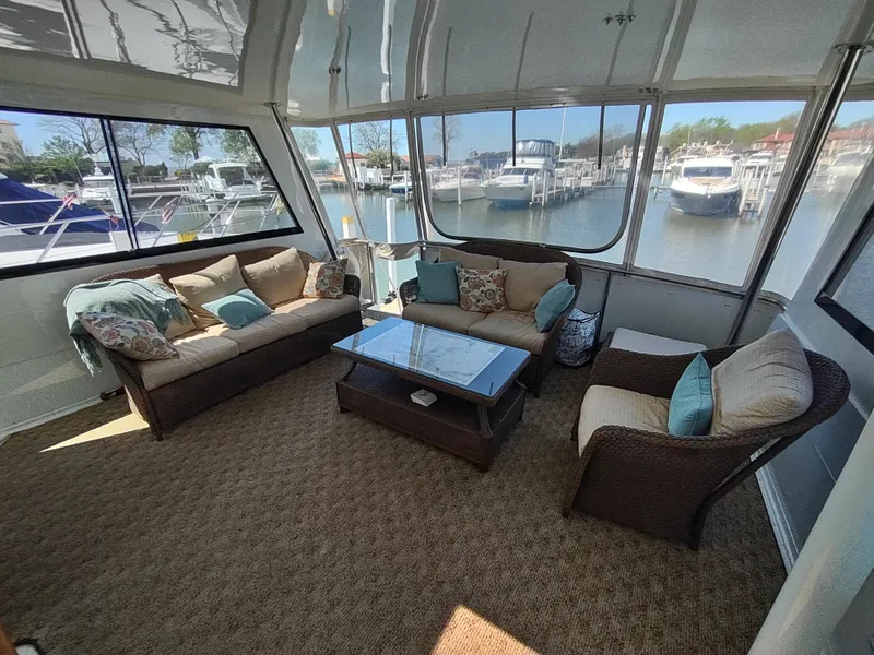 Slide: The Image of Spacious interior of 1995 Hatteras 52 Cockpit Motor Yacht with comfortable seating and marina view. - 7